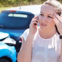 woman on the phone after getting into an accident