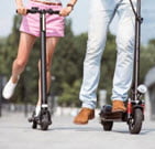 woman and a man on an electric scooter