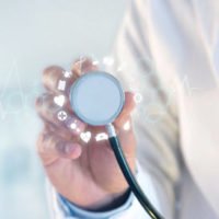 doctor holding the end of his stethoscope 