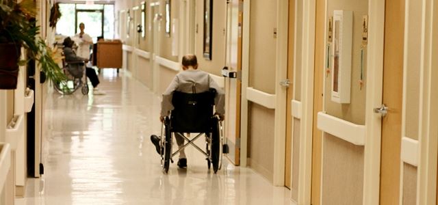 a person sitting in a wheelchair in a hallway