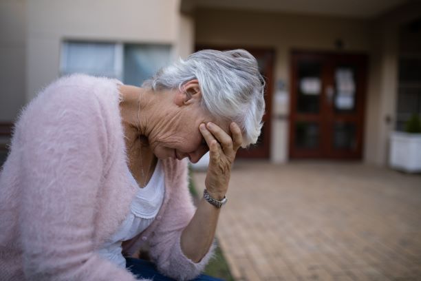 an old woman holding his hand to his face