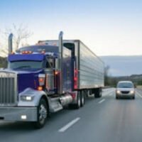 Big truck driving next to a car