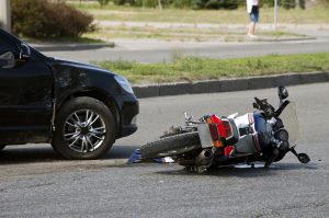 Motorcycle laying on the floor in front of a car