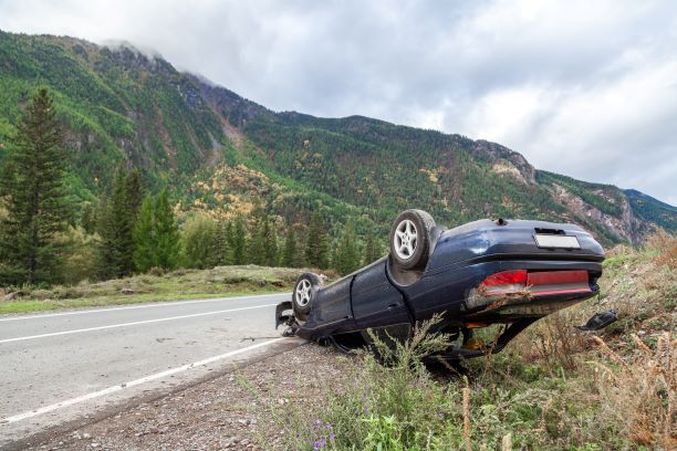 Flipped car on the side of the road 