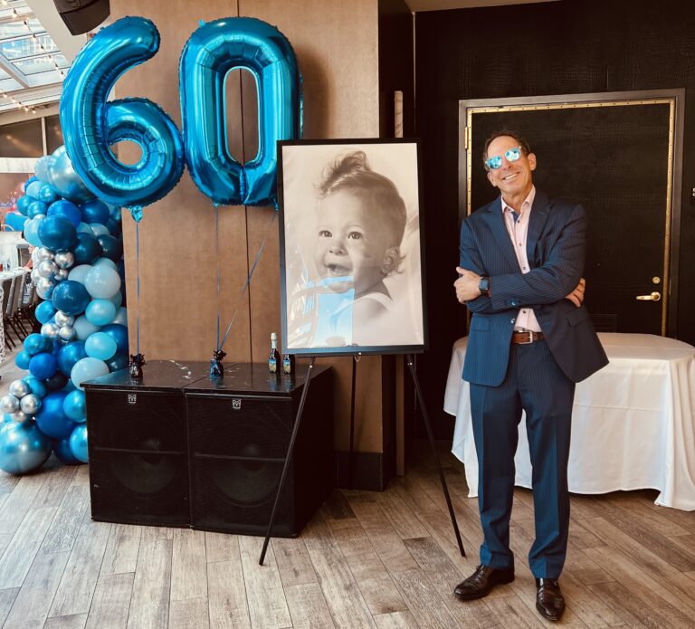 a person standing in a room with balloons and a painting