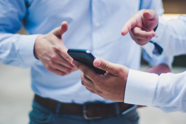 Two drivers exchanging insurance information on a phone and reach out to auto accident lawyers Chicago