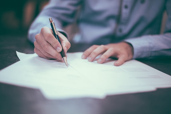 One of the best Chicago wrongful death attorneys signing paperwork on a desk.