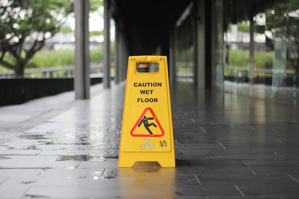 A wet floor sign is placed on a slippery walkway after contacting a Chicago slip and fall accident lawyer proved negligence