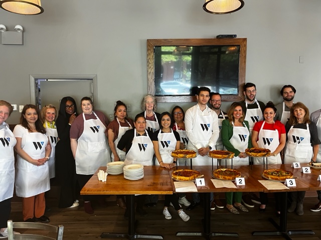 a group of people standing around a table with food on it