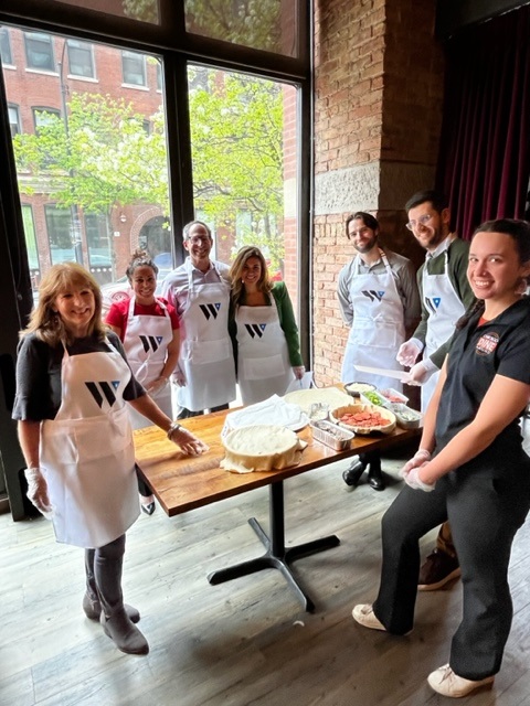 a group of people standing around a table with food on it