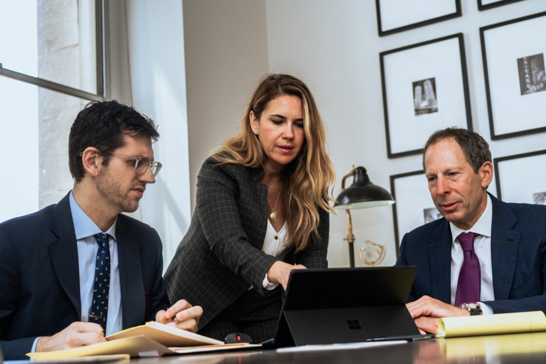 Jonathan Walner et al. sitting at a table looking at a laptop