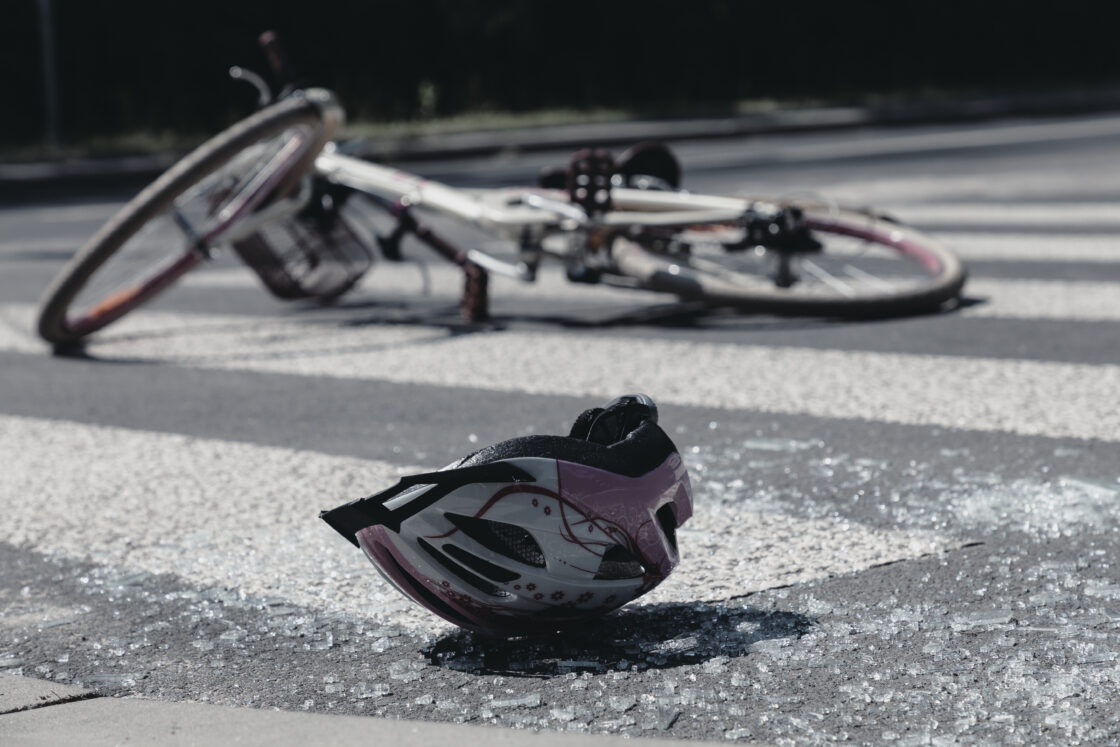 Broken child's helmet and bike on pedestrian cross