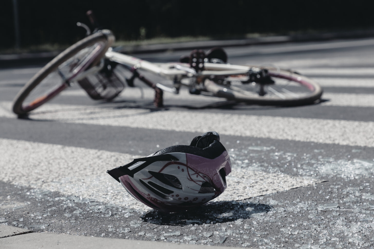 Broken child's helmet and bike on pedestrian cross