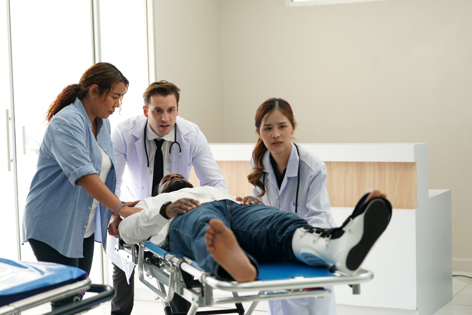 A man in the hospital on a structure being moved by doctors