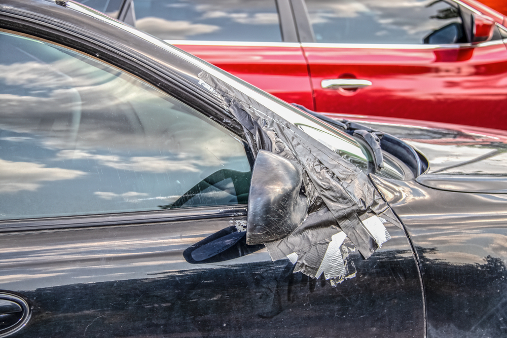 Severely damaged car side after a high-speed sideswipe crash, showing crushed doors and exposed frame.
