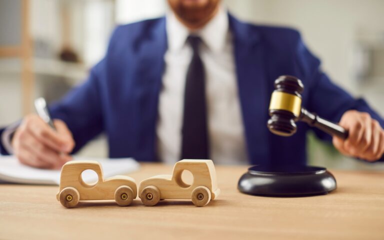Injured person consults lawyer in office, discussing options for suing after a car accident.