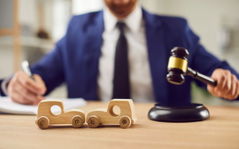 Injured person consults lawyer in office, discussing options for suing after a car accident.