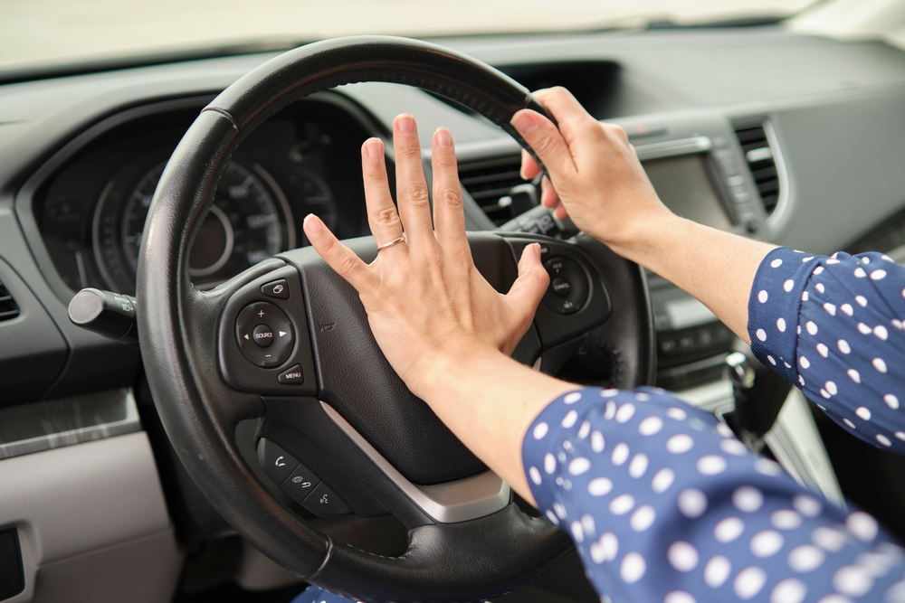 Angry driver yelling and gesturing behind the wheel, illustrating aggressive road rage behavior.