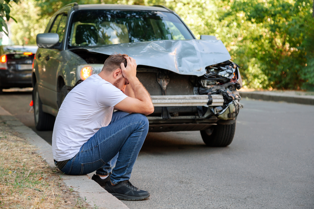 Frustrated driver reads insurance policy after crash, discovering the other driver is uninsured or underinsured.
