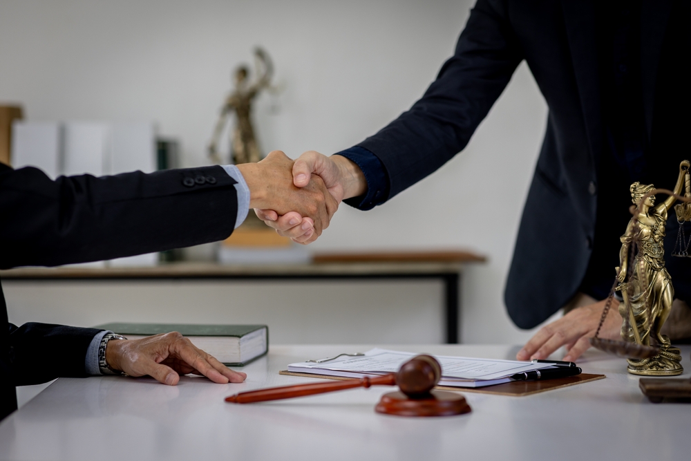 Person shaking hands with lawyer in office, symbolizing trust and support after a car accident claim.