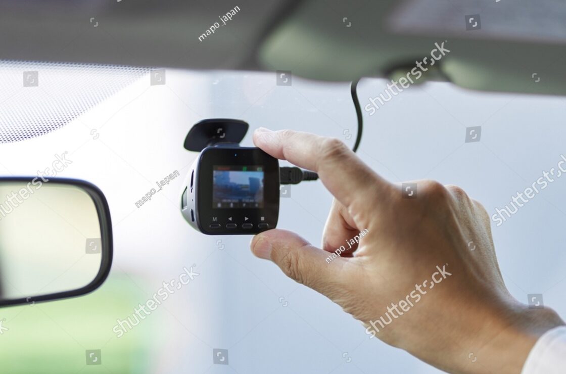 Male driver reviewing footage on a dashcam, demonstrating how to document incidents during a road rage encounter for safety.