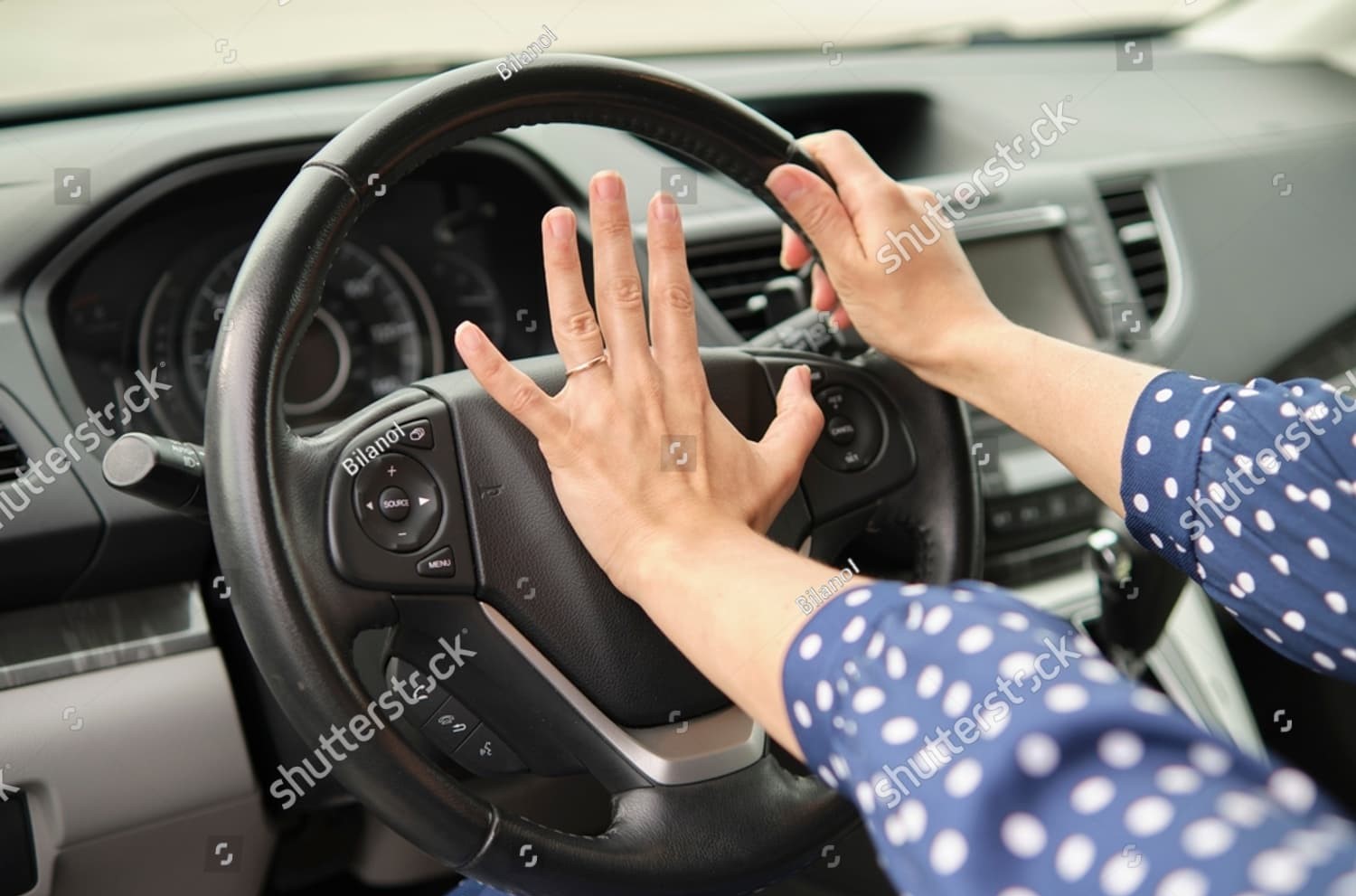 Woman urgently honks car horn to avoid collision—an example of defensive action amid escalating road rage scenarios.