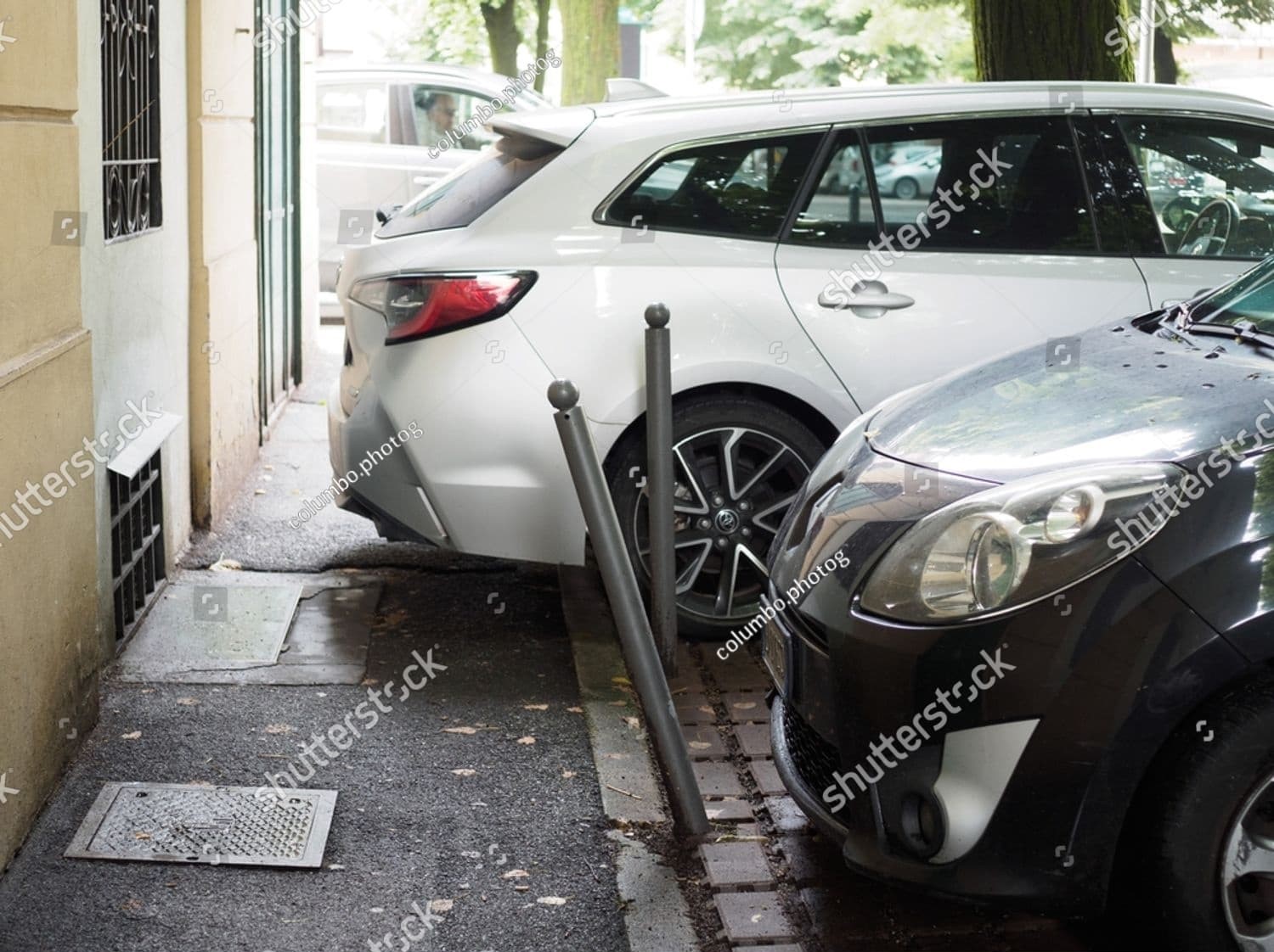 White car parked on a city street sideswipes a black car, causing minor damage and a dislodged side mirror
