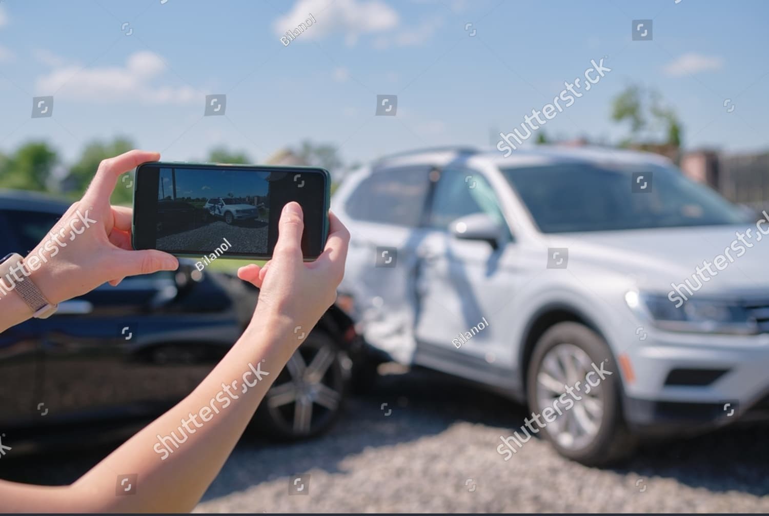 Female driver photographs damaged cars after sideswipe collision—documenting evidence for insurance and legal purposes.