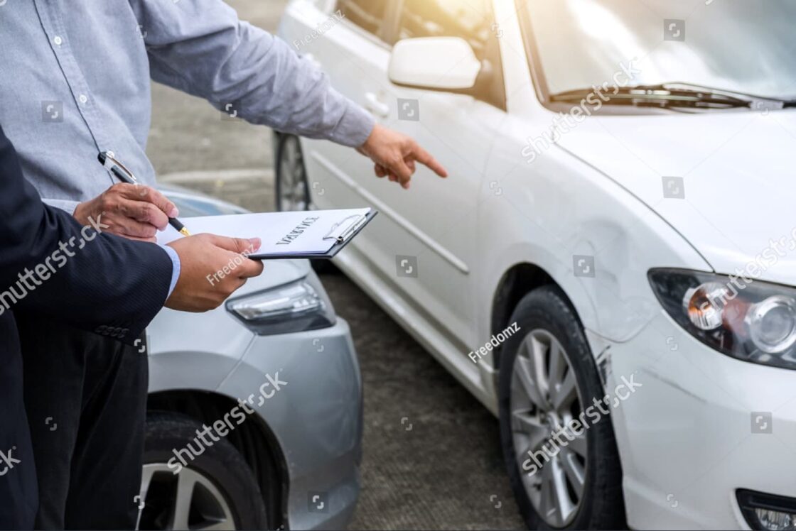 Insurance agent inspecting car damage and filing a claim report after accident; highlights post-crash steps and documentation.