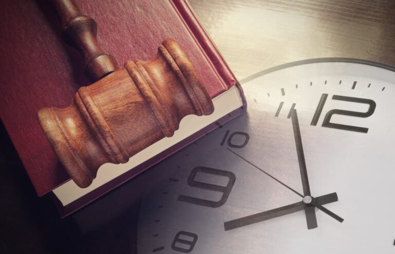 A Wall Clock along with Judge's Gavel on a book