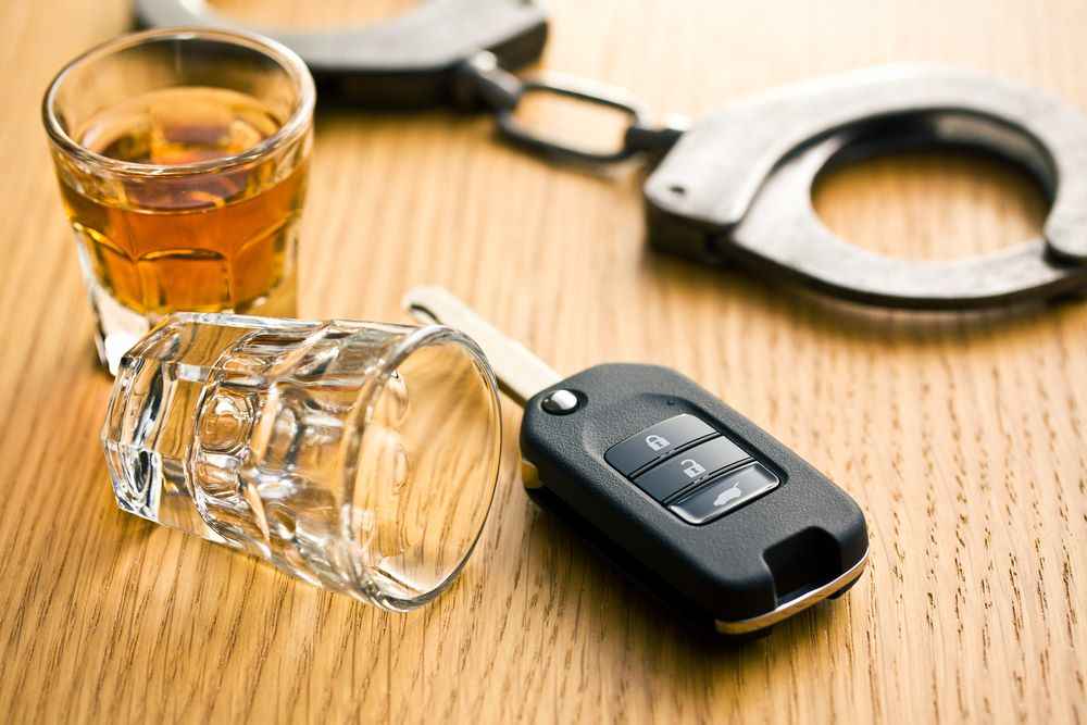Hand Cuffs, a glass of alcohol and car key