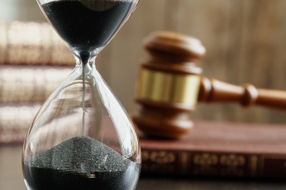 Hourglass and judge gavel on table close up - Concept of legal timeline