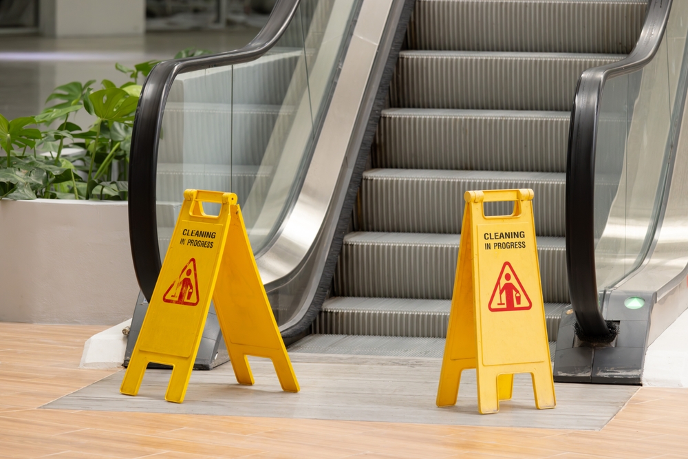 Caution: Wet Floor Standees at the foot of a mall escalator
