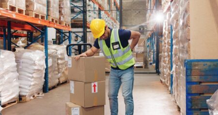 Warehouse worker experiencing pain from repetitive motion injury
