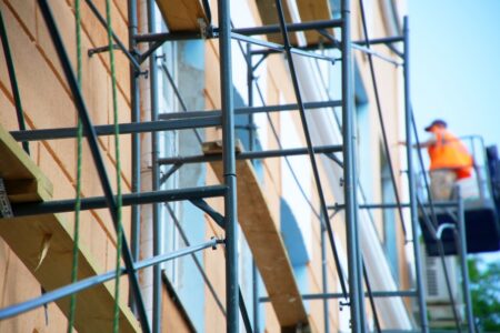 Construction worker on scaffolding, performing work on the face of a building
